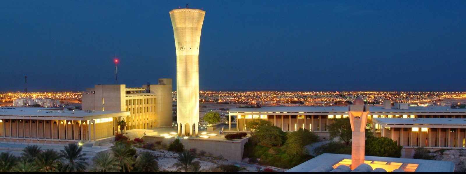 KFUPM water tower illuminated at night above the campus